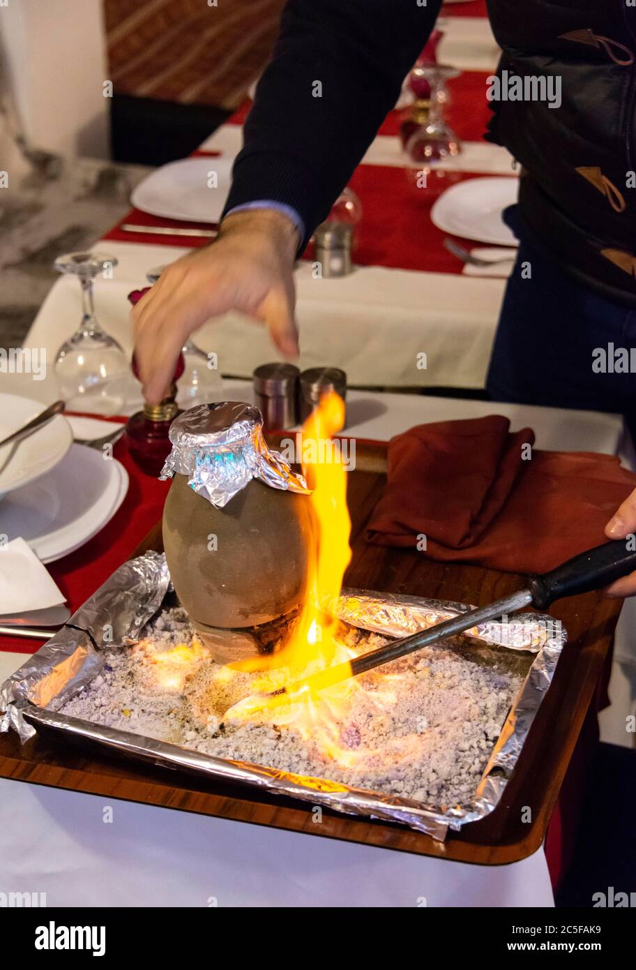 Der Kebab wird mit Feuer in einem Restaurant serviert, der Kebab wird in einem Steinguttopf geschmort, typisch türkisches Gericht aus Kappadokien, Istanbul, Türkei Stockfoto