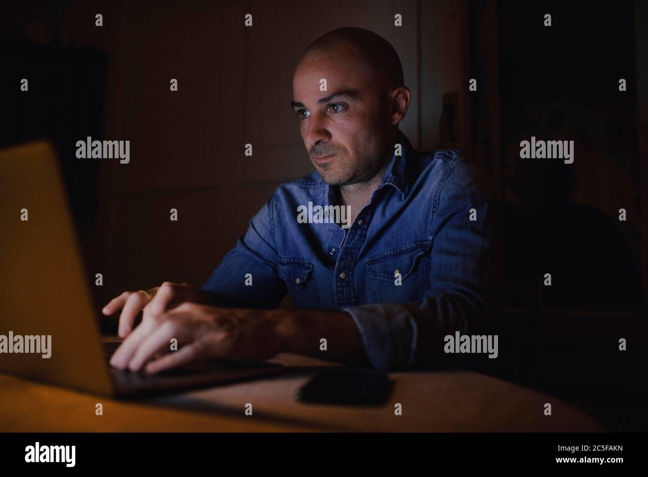 Mann arbeitet nachts am Computer, Österreich Stockfoto