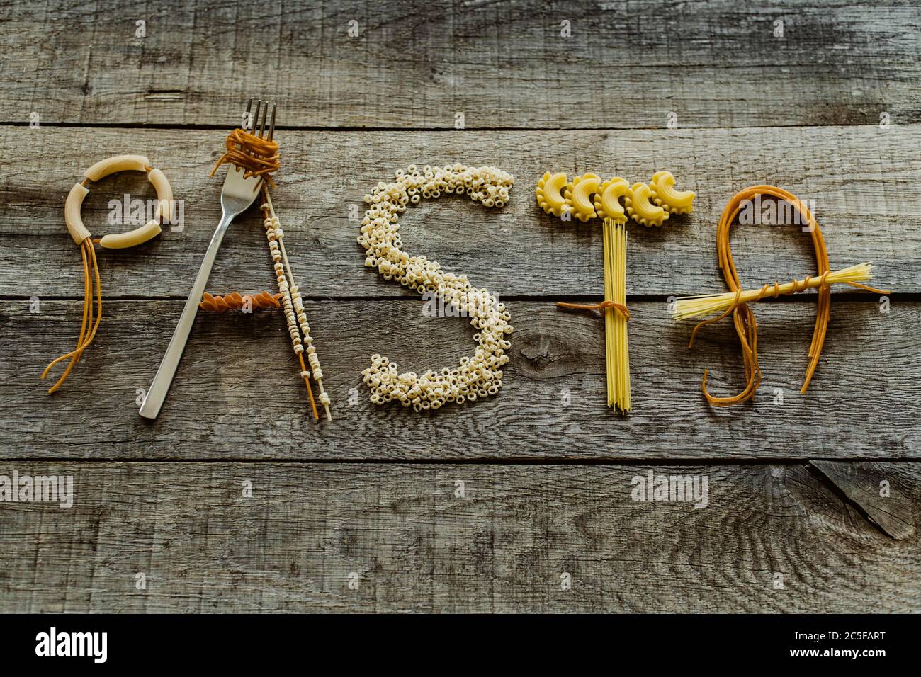 Wort Pasta aus verschiedenen Nudeln auf Holztisch, Pasta Stockfoto