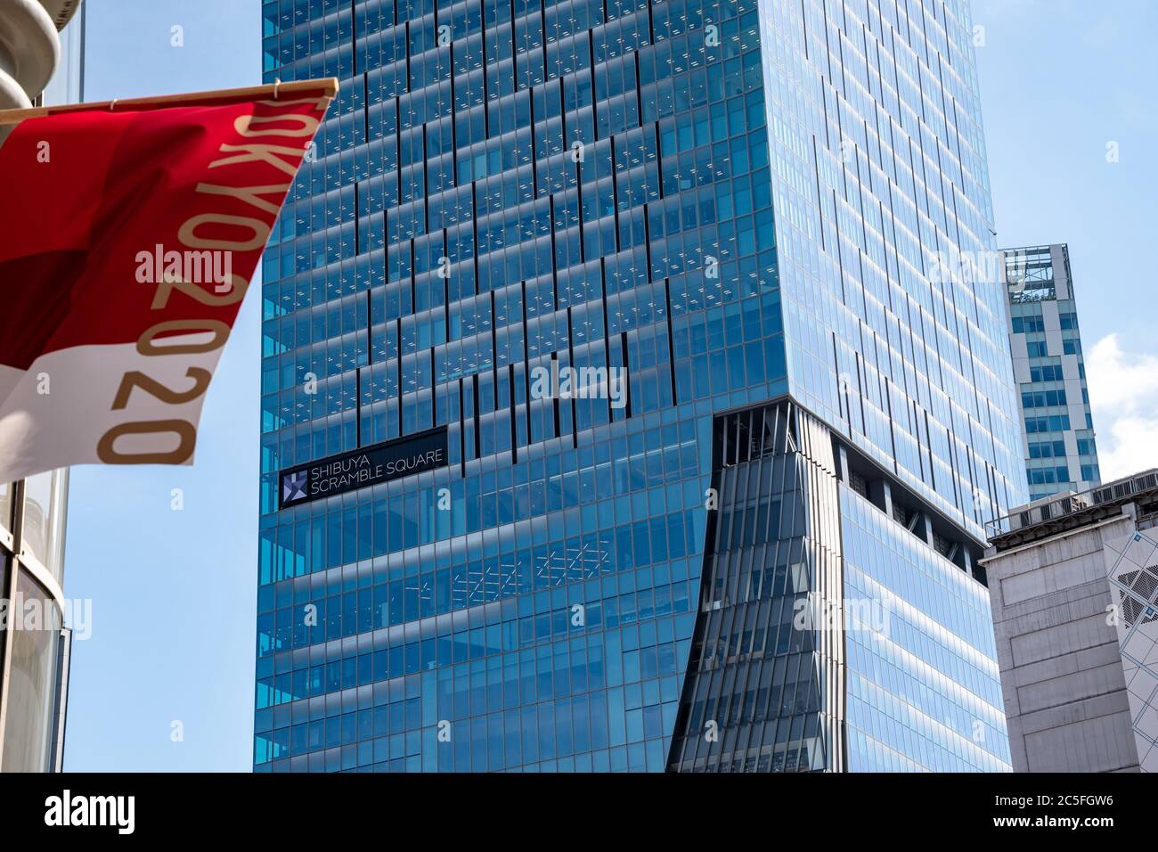 Tokyo 2020 Banner flattert im Wind. Shibuya Scramble Square Gebäude im Hintergrund. Stockfoto