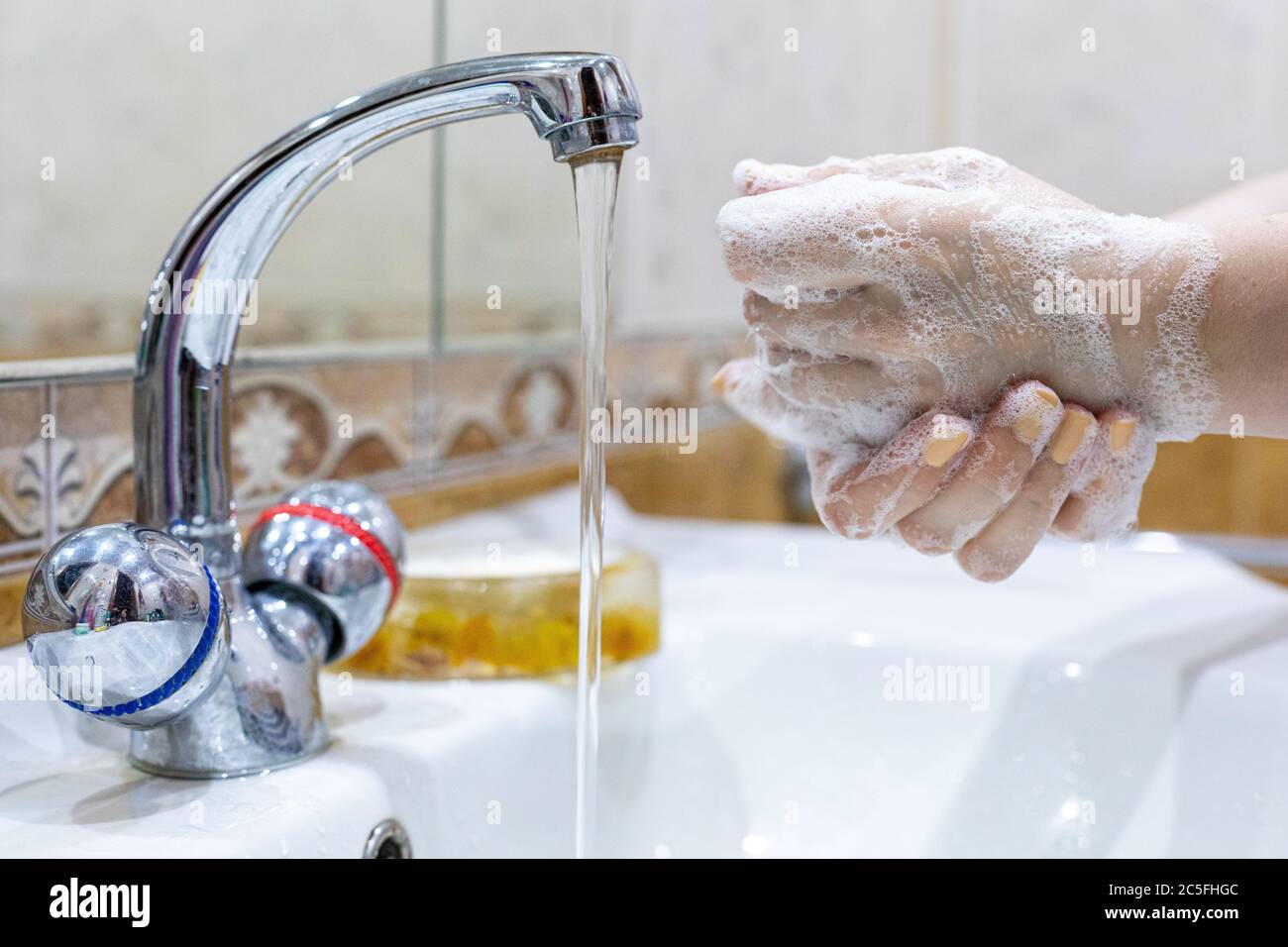 Das Mädchen wäscht ihre Hände mit Seife unter dem Wasserhahn mit Wasser. Körperpflege. Desinfektion. Hygienekonzept. Corona Virus Prävention zu stoppen Stockfoto Das Mädchen wäscht ihre Hände mit Seife unter dem Wasserhahn mit Wasser. Körperpflege. Desinfektion. Hygienekonzept. Corona Virus Prävention zu stoppen Stockfoto