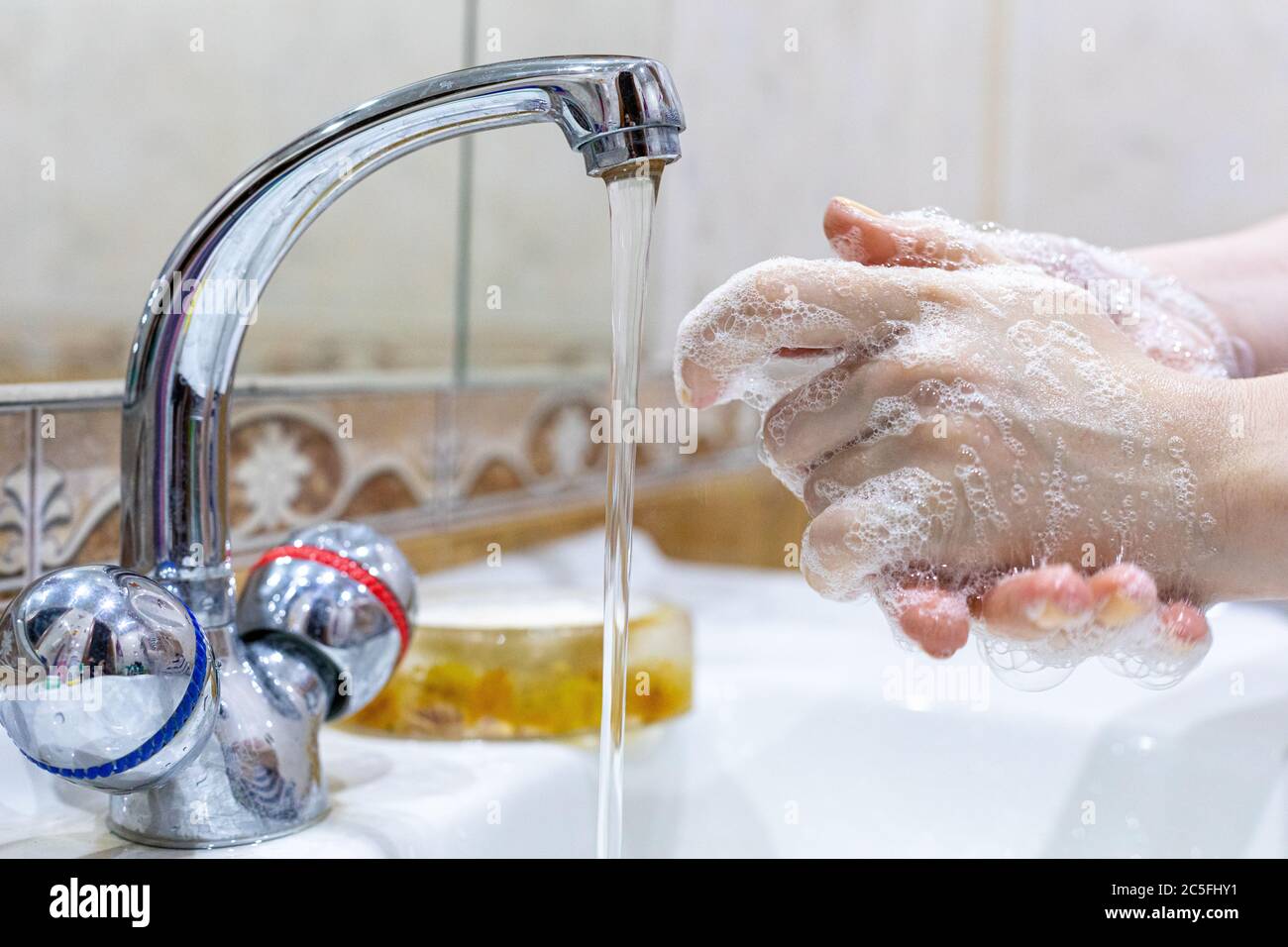 Das Mädchen wäscht ihre Hände mit Seife unter dem Wasserhahn mit Wasser. Körperpflege. Desinfektion. Hygienekonzept. Corona Virus Prävention zu stoppen Stockfoto Das Mädchen wäscht ihre Hände mit Seife unter dem Wasserhahn mit Wasser. Körperpflege. Desinfektion. Hygienekonzept. Corona Virus Prävention zu stoppen Stockfoto