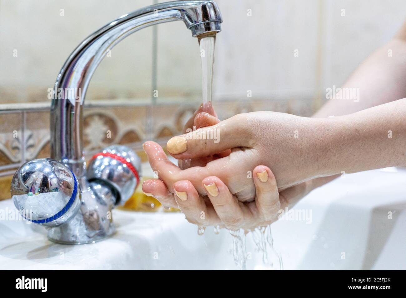 Das Mädchen wäscht ihre Hände mit Seife unter dem Wasserhahn mit Wasser. Körperpflege. Desinfektion. Hygienekonzept. Corona Virus Prävention zu stoppen Stockfoto Das Mädchen wäscht ihre Hände mit Seife unter dem Wasserhahn mit Wasser. Körperpflege. Desinfektion. Hygienekonzept. Corona Virus Prävention zu stoppen Stockfoto
