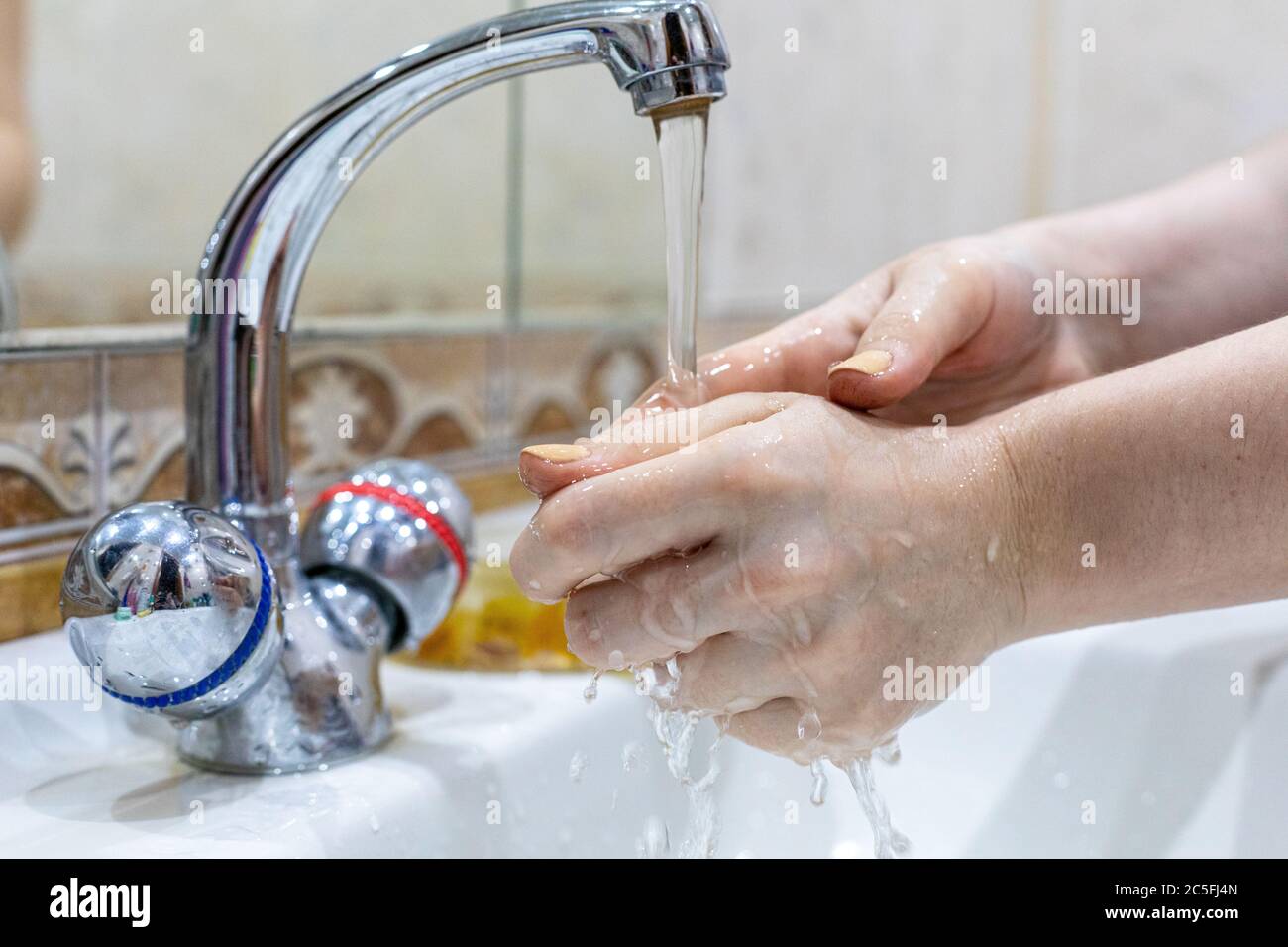 Das Mädchen wäscht ihre Hände mit Seife unter dem Wasserhahn mit Wasser. Körperpflege. Desinfektion. Hygienekonzept. Corona Virus Prävention zu stoppen Stockfoto Das Mädchen wäscht ihre Hände mit Seife unter dem Wasserhahn mit Wasser. Körperpflege. Desinfektion. Hygienekonzept. Corona Virus Prävention zu stoppen Stockfoto