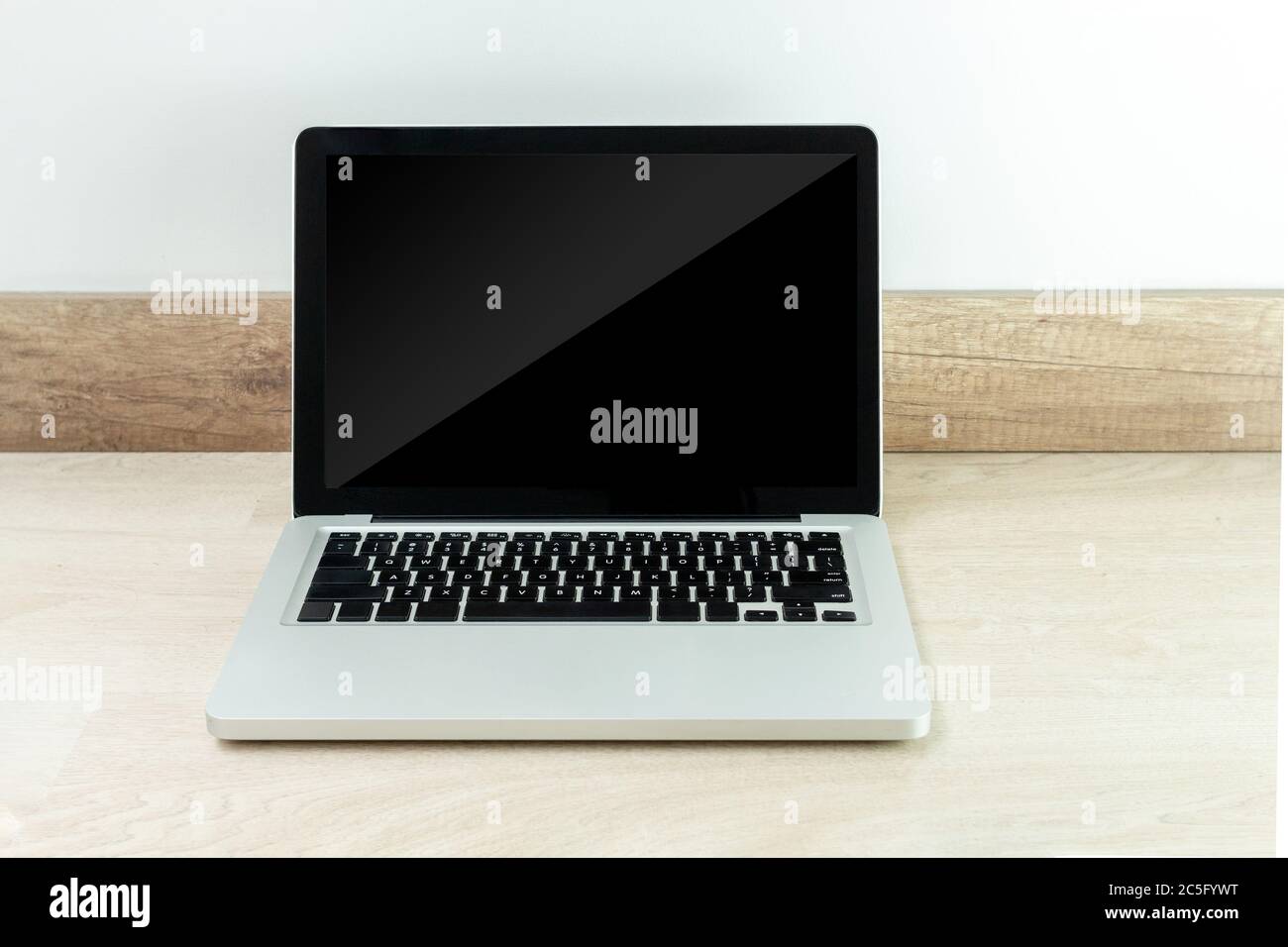 Laptop auf einem Holzschreibtisch mit schwarzem Monitor, um den Inhalt zu finden Stockfoto