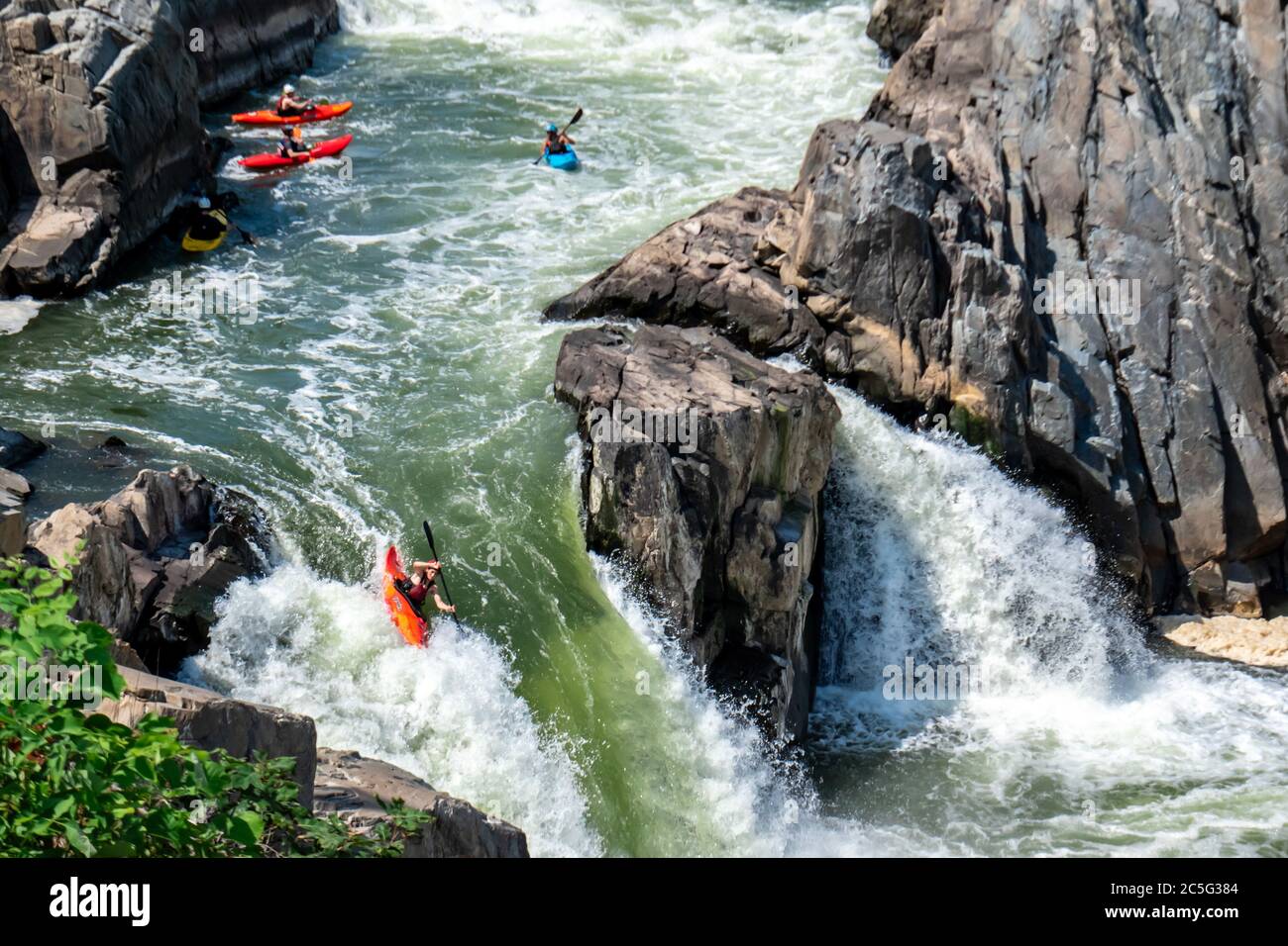 Tapfere Flussenthusiasten paddeln ihre Kajaks durch den Potomac River. Extremsport und Wildwasser-Rafting in schnellen, gefährlichen Schluchten. Stockfoto