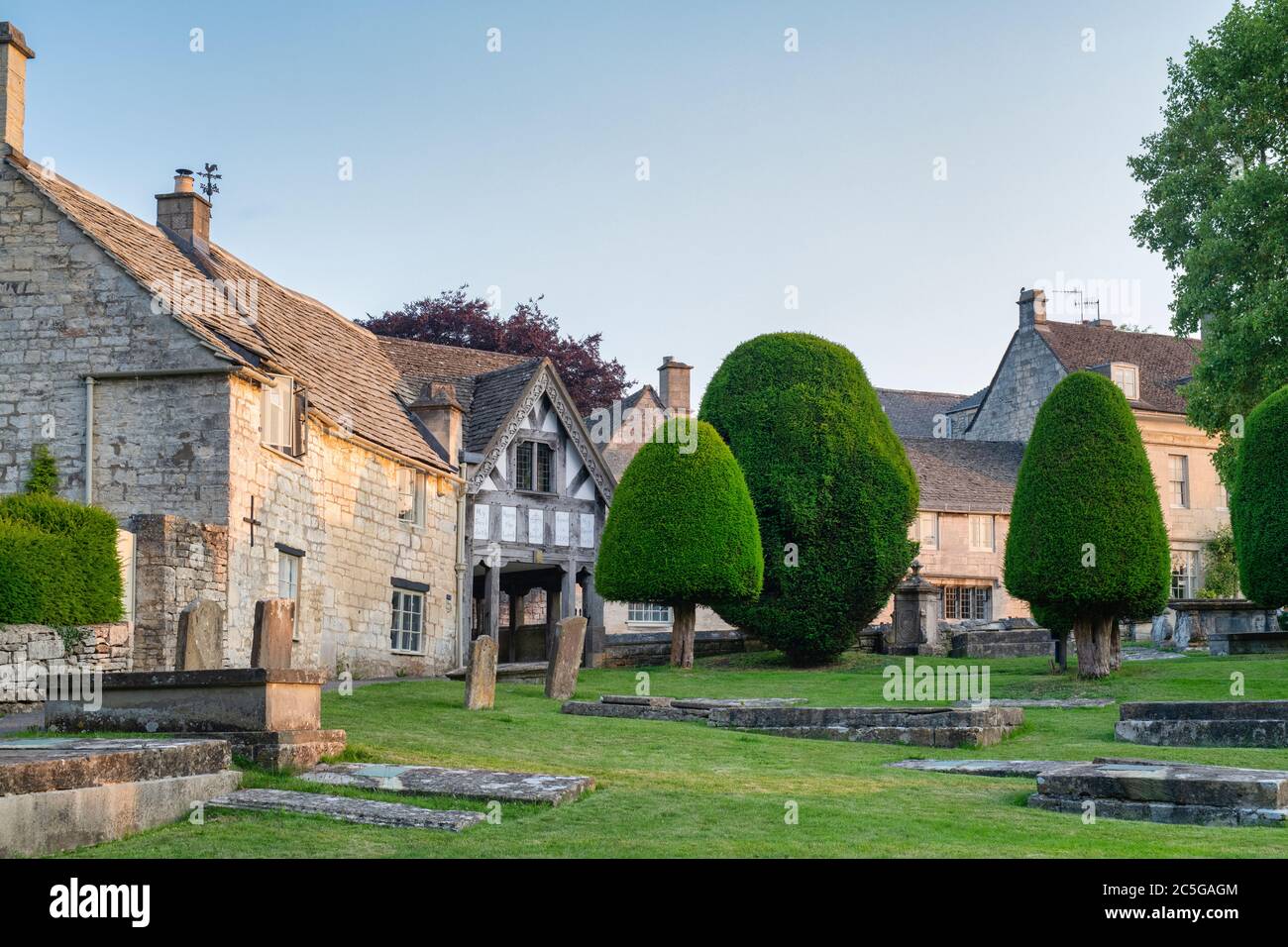 St Marys Kirche Lychgate und Eibenbäume bei Sonnenaufgang. Painswick, Cotswolds, Gloucestershire, England Stockfoto