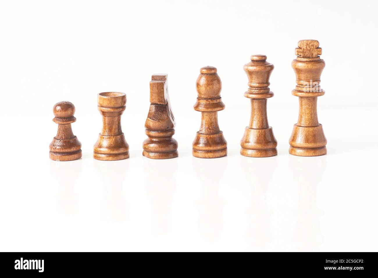 Schachfiguren aus Holz isoliert gegen Weiß Stockfoto