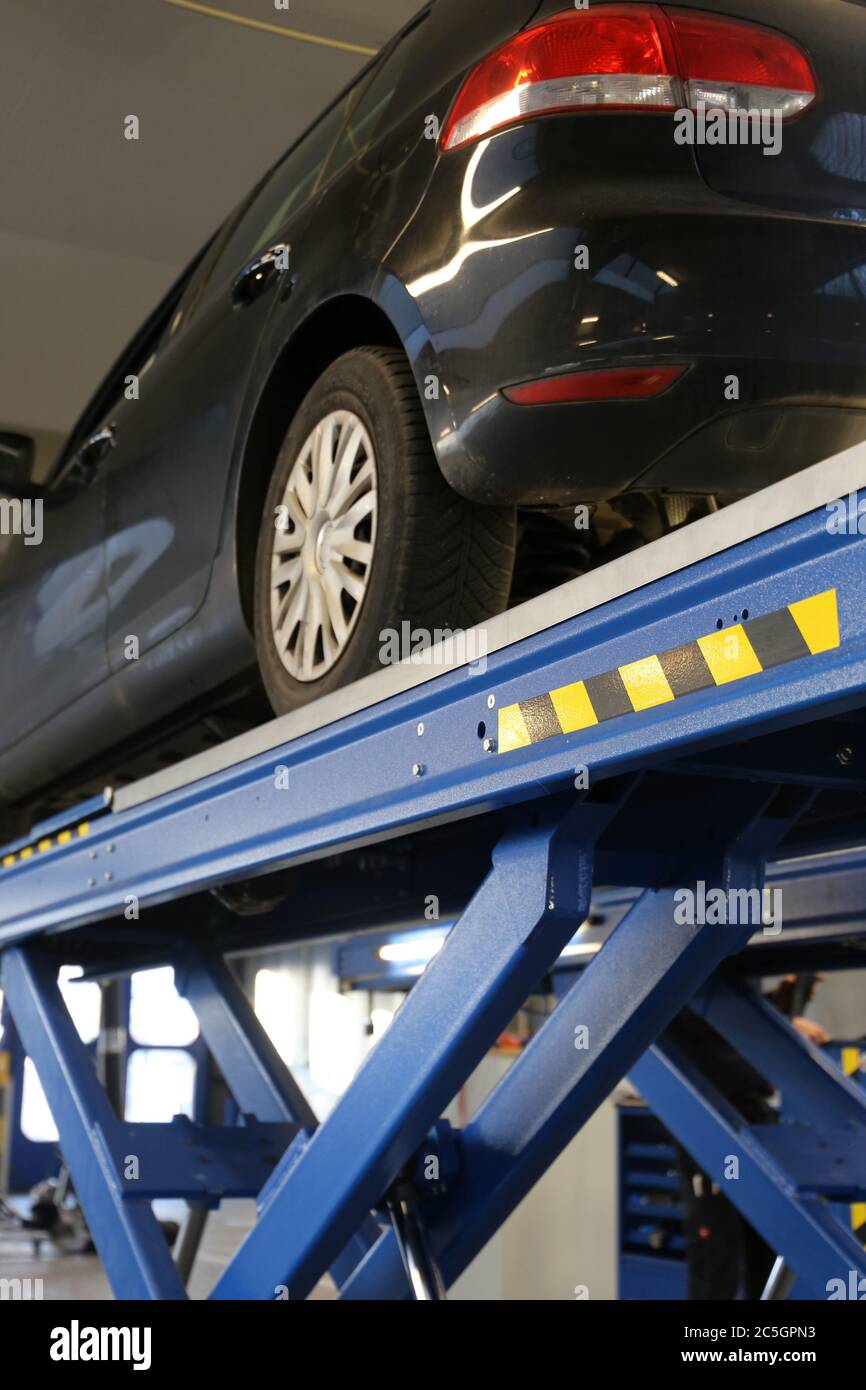 Reparaturwerkstatt: Auto auf der Hebebühne Stockfoto