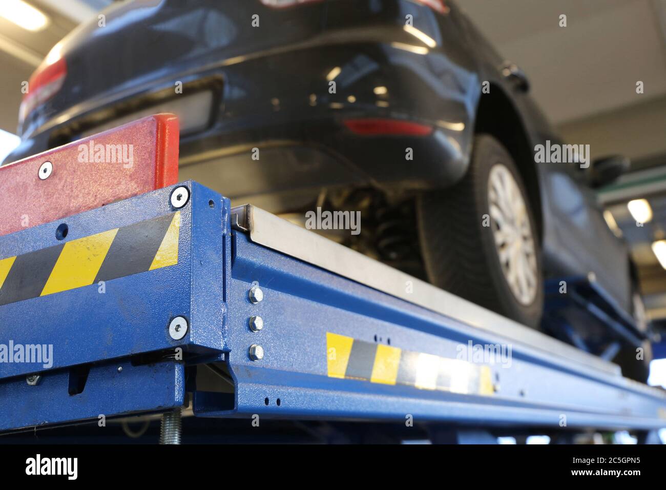 Reparaturwerkstatt: Auto auf der Hebebühne Stockfoto