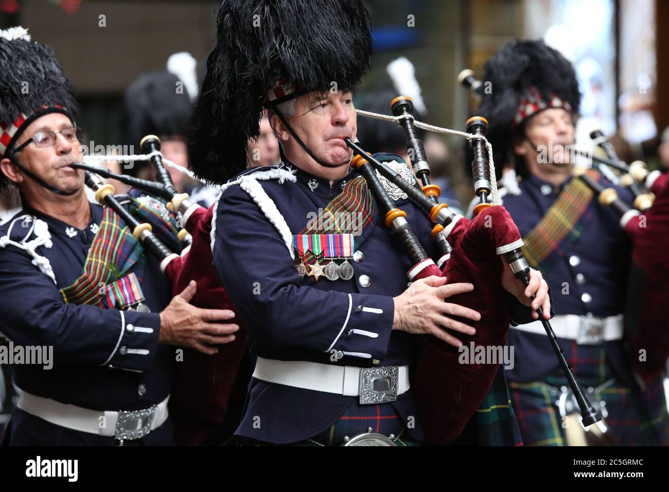 Soldaten spielen Dudelsack, während sie in der ANZAC Day Parade in Sydney entlang der George Street marschieren. Stockfoto