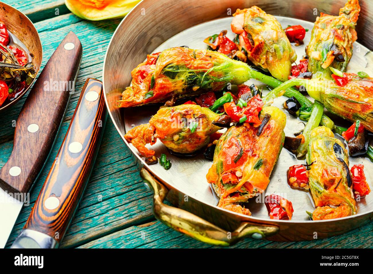 Köstliche gebratene Zucchini Blumen gefüllt mit sonnengetrockneten Tomaten.Sommer Essen. Stockfoto