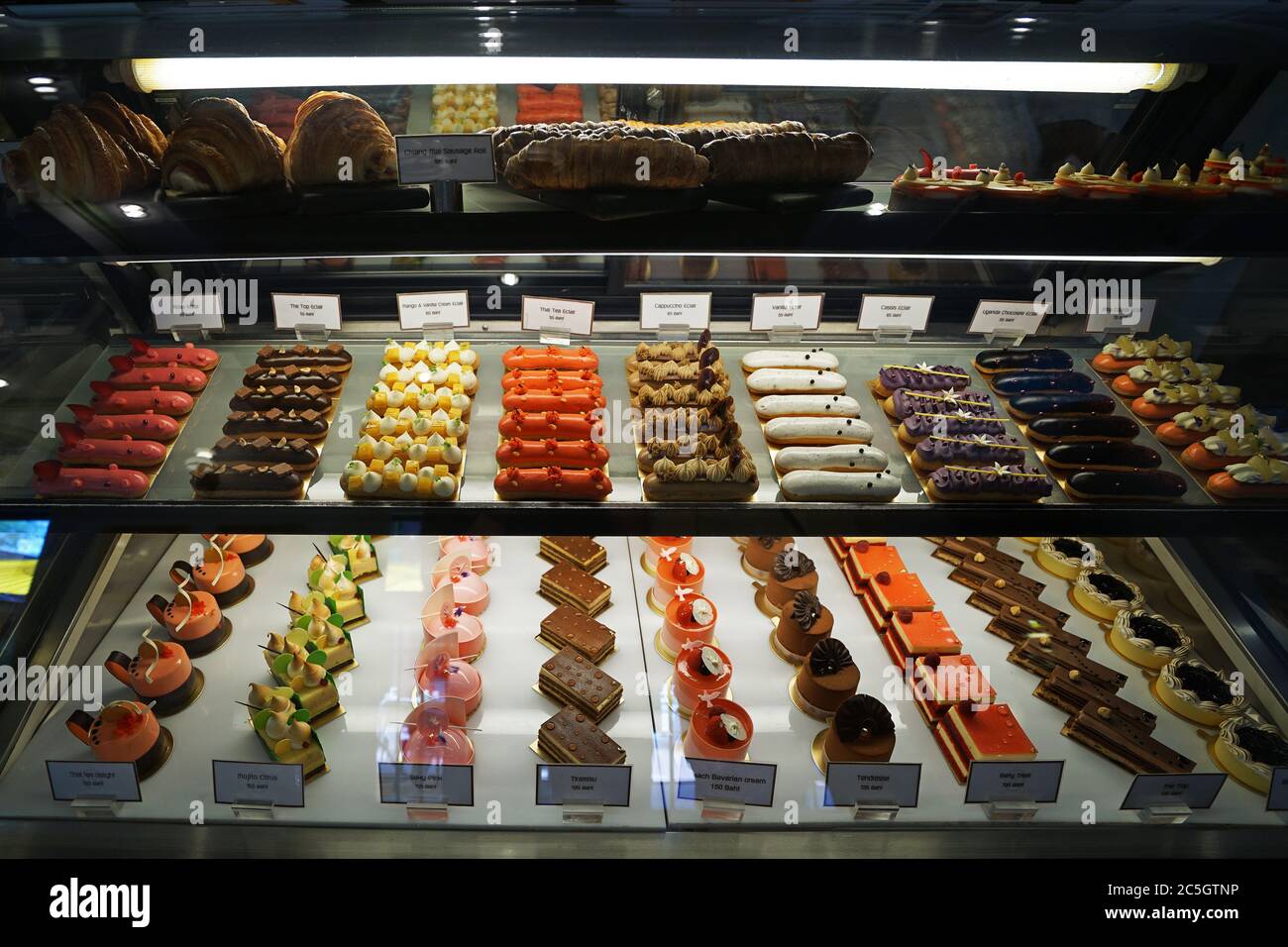 Verschiedene Geschmack bunte eclair und Französisch Gebäck Bäckerei in Glas Vitrine Box angezeigt Stockfoto