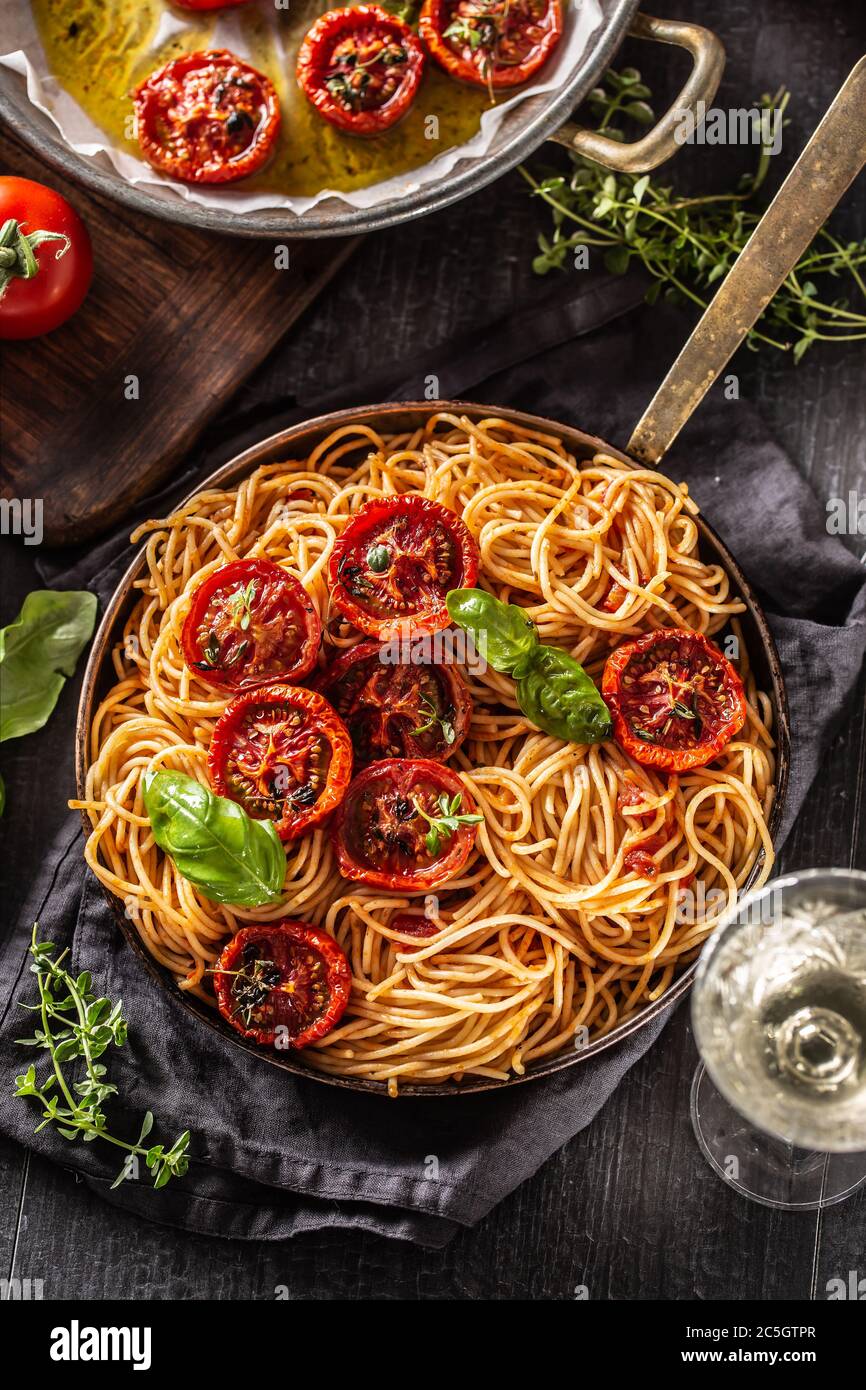 Italienische Pasta Spaghetti mit gerösteten Tomaten Basilikum Oregano Thymian und weißen Reben Stockfoto