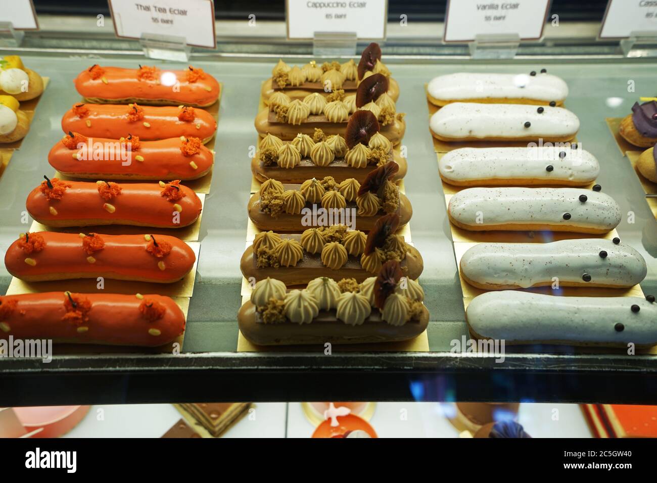 Verschiedene Geschmack bunte eclair und Französisch Gebäck Bäckerei in Glas Vitrine Box angezeigt Stockfoto