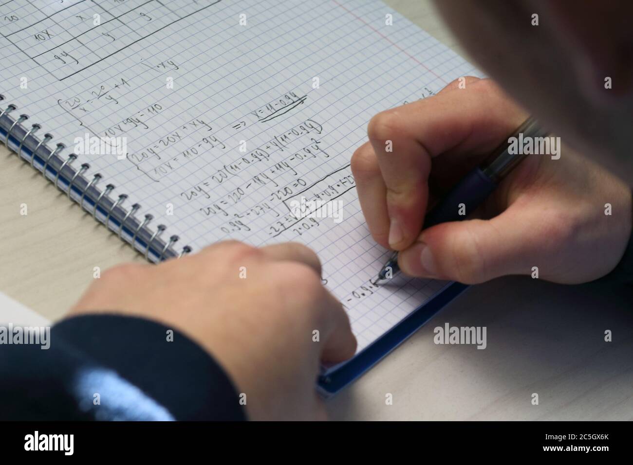 Lösen einer Systemgleichung in der High School. Nahaufnahme. Stockfoto