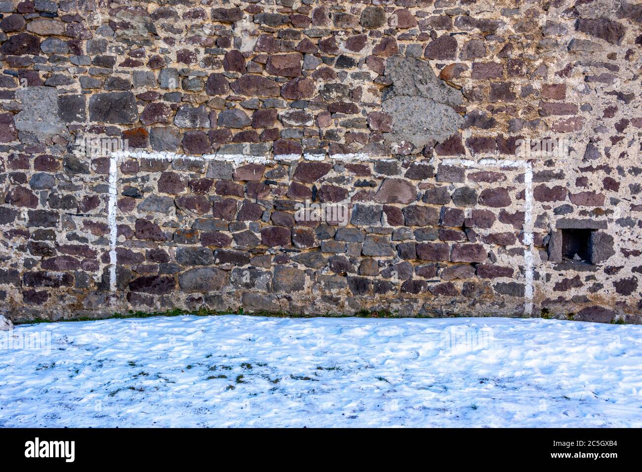 Bemalte Fußball-Torpfosten auf einer Steinmauer im Winter, Frankreich Stockfoto