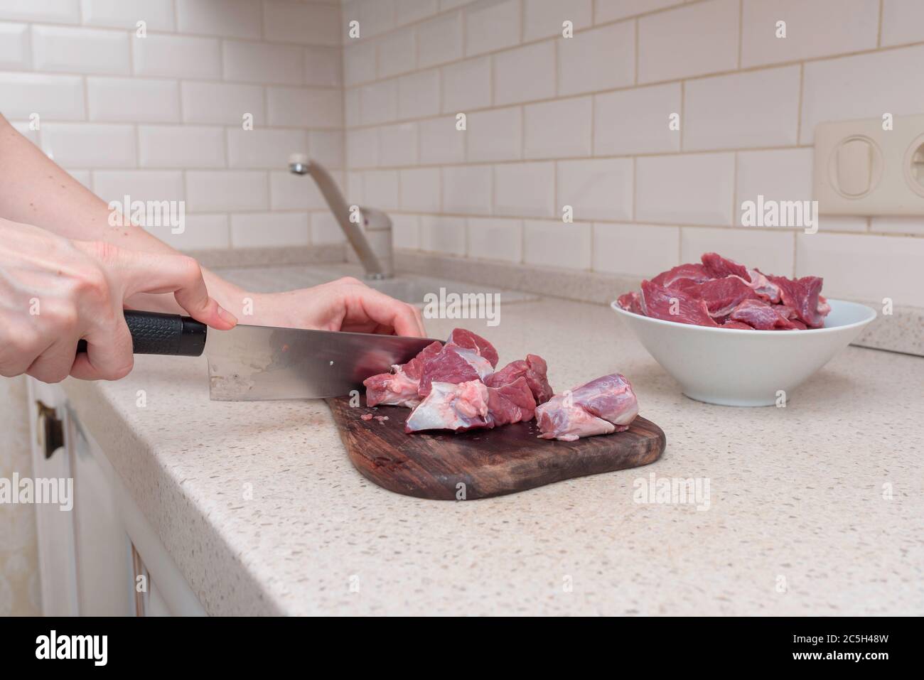 Küchenchef, schneiden das Fleisch auf einem Holzbrett Stockfoto