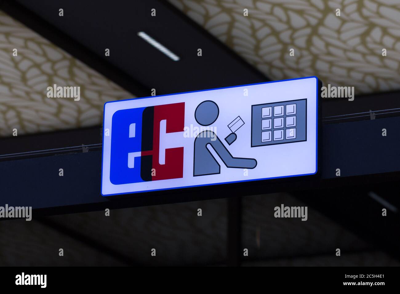 Blick auf EC (Electronic Cash) Logo / Neon-Schild mit Tastatur und eine Figur mit einer Karte. Stockfoto