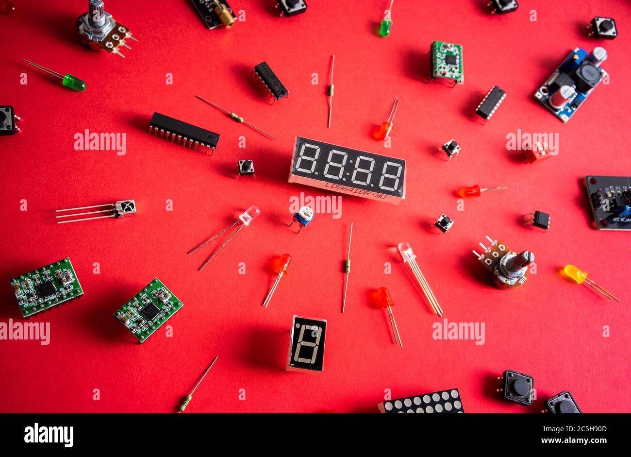 Micro Elektronik arduino DIY Komponenten über rotem Hintergrund, Draufsicht, Kopierraum. Mikrocontroller, Platinen, Sensoren, leds, Controller Stockfoto