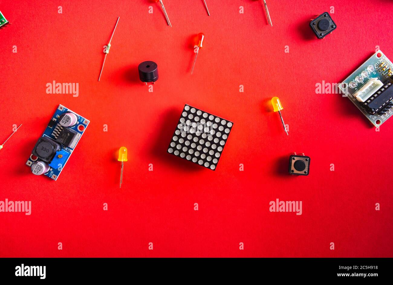 Micro Elektronik arduino DIY Komponenten über rotem Hintergrund, Draufsicht, Kopierraum. Mikrocontroller, Platinen, Sensoren, leds, Controller Stockfoto