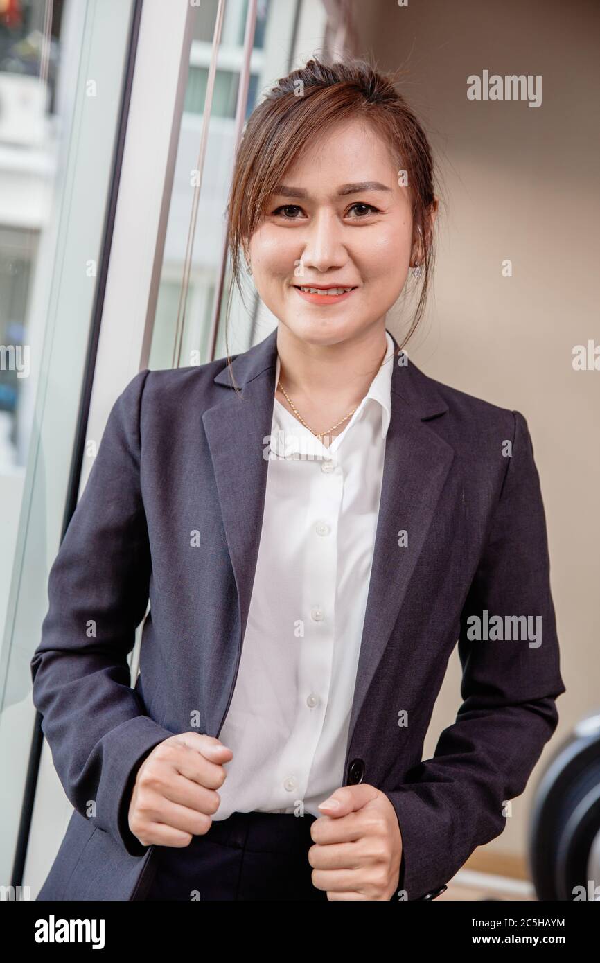 Business Südostasien Thai Frau Erwachsene 40er Jahre Vertrauen stehend lächelnd mit Dressing Suite vertikalen Schuss für Firmenwerbung. Stockfoto