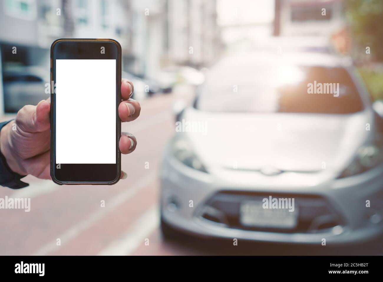 Hand Handy-Smartphone leeren Bildschirm mit Auto Fahrzeug für Smartphone-App-Hintergrund-Konzept. Stockfoto