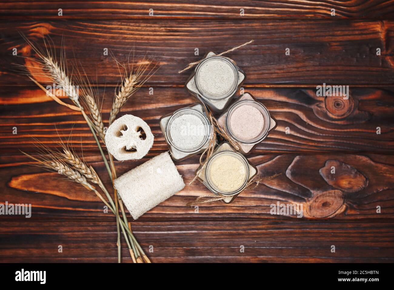 Kräuter Bio Ubtan in Glasflasche auf dunkler Holzhintergrund Stockfoto
