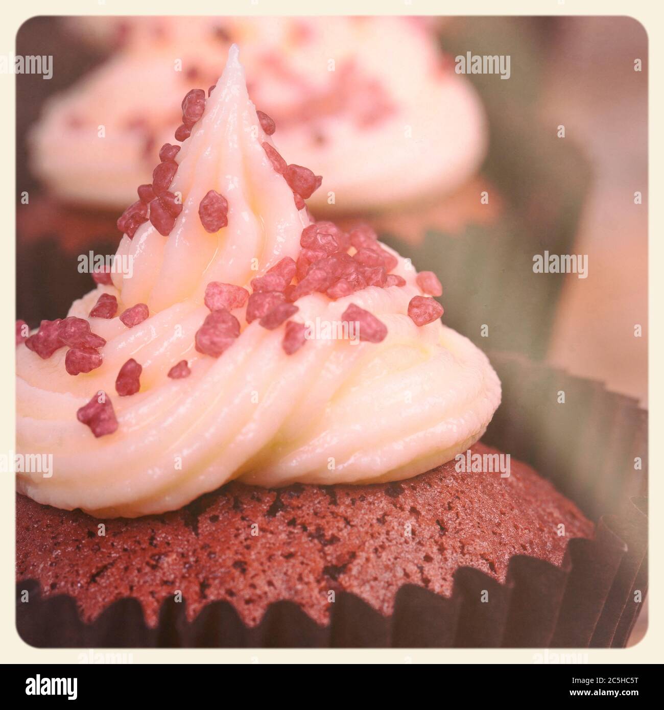 Cupcake aus rotem Samt. Gefiltert, um wie ein veraltertes Sofortfoto zu aussehen. Stockfoto