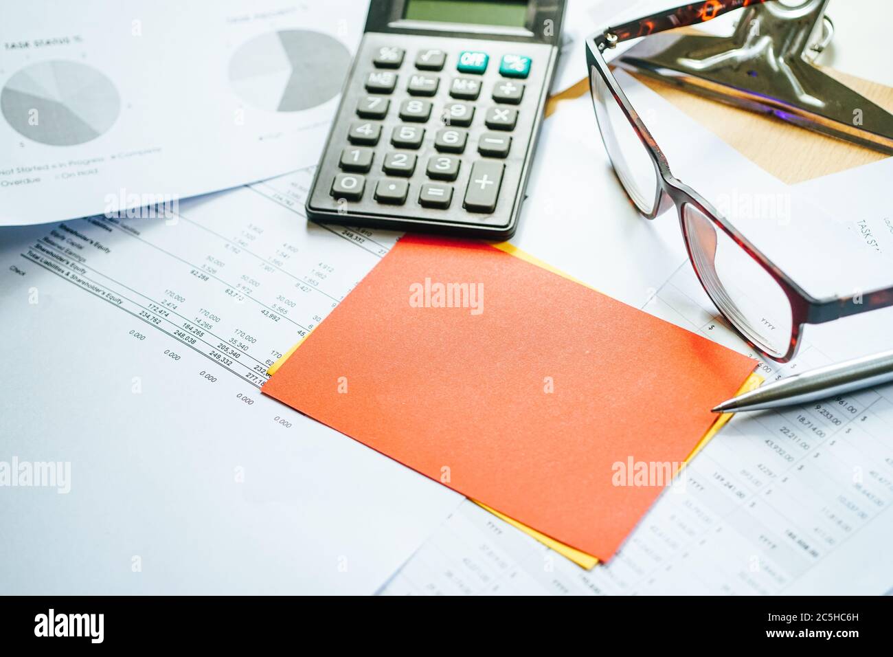 Finanzbudget Bericht Papier mit einem Rechner, Stift, Glas und roten Post it Note. Selektiver Fokus Stockfoto