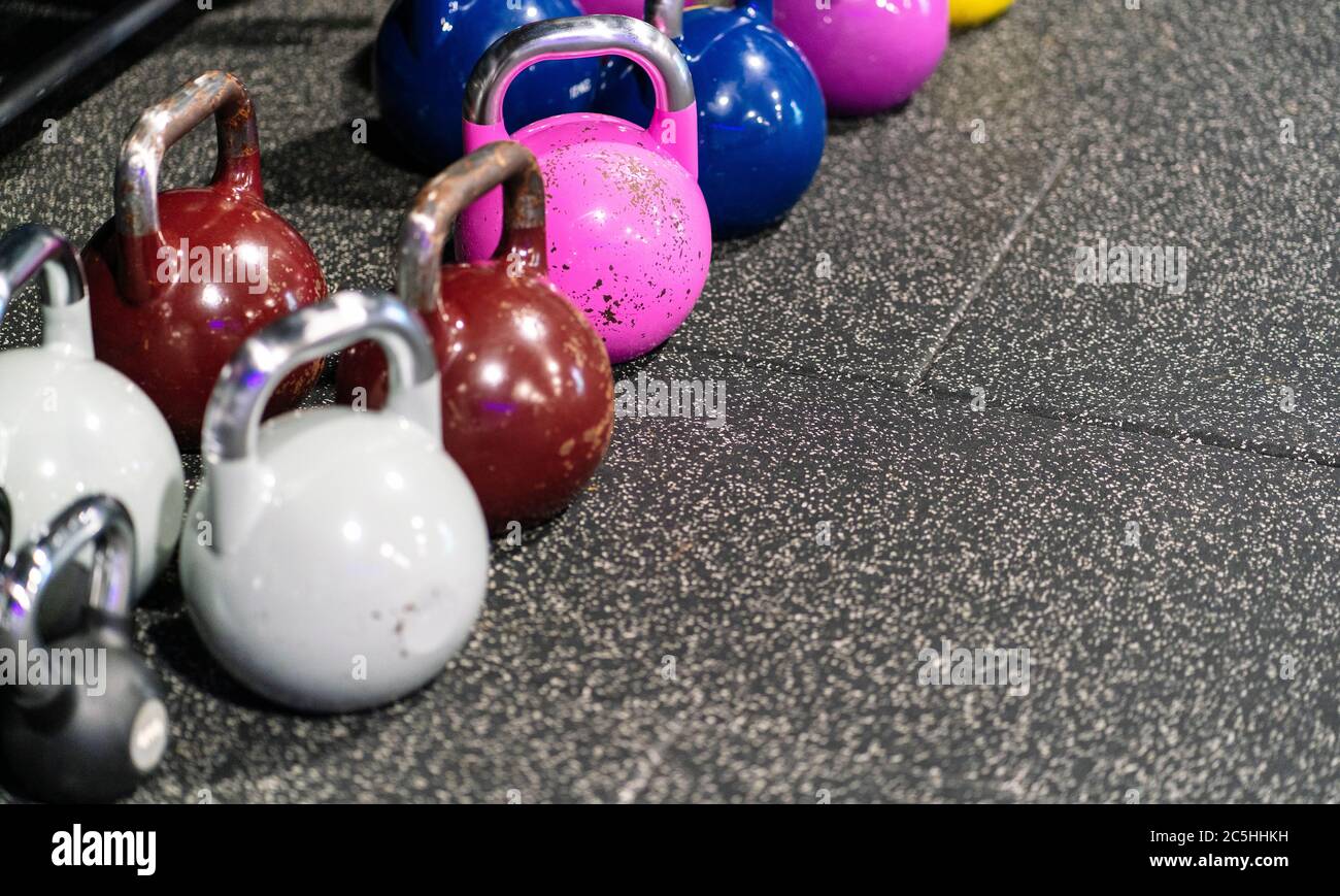 Farbige Trainingsbanteln auf einem Fitnessboden Stockfoto