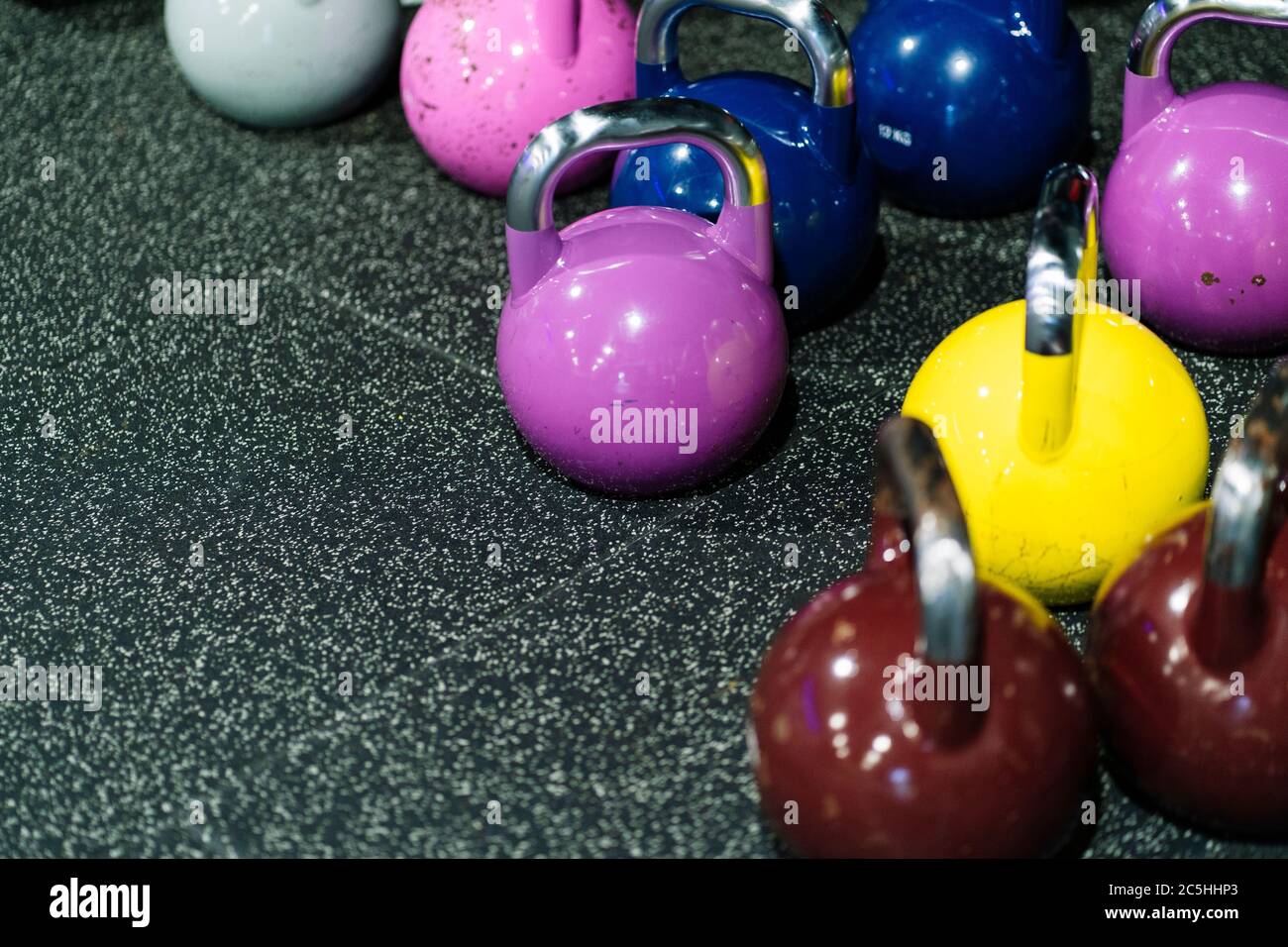 Farbige Trainingsbanteln auf einem Fitnessboden Stockfoto