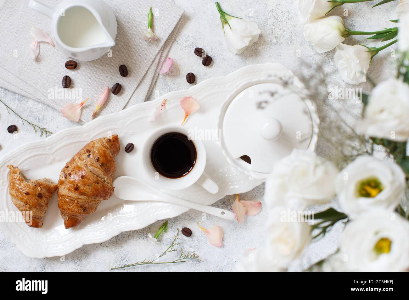 Romantisches Frühstückstablett mit Kaffeetasse und Croissant-Blick von oben Stockfoto