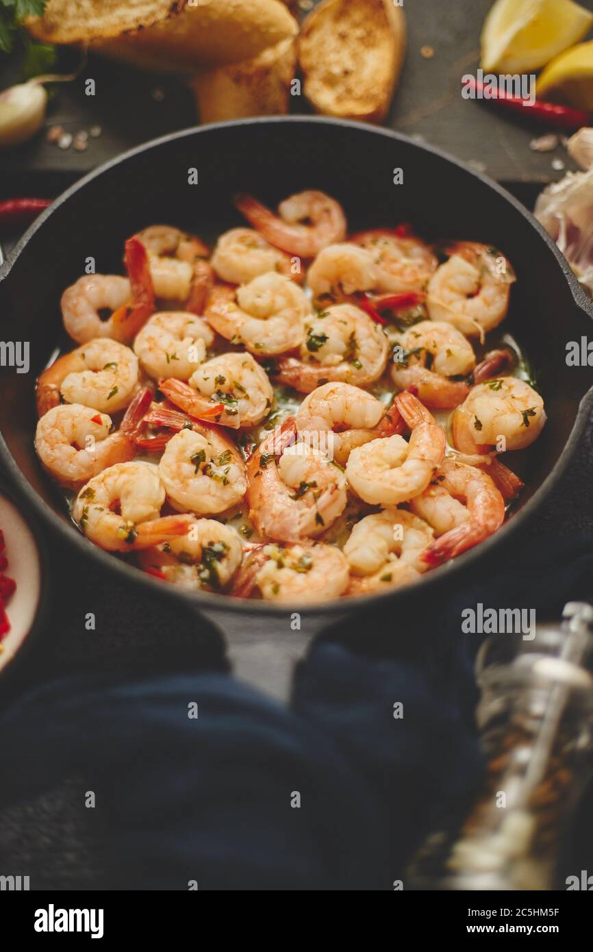 Leckere Garnelenschwänze in Butter gebraten mit, Knoblauch, Petersilie, Weißwein Chili. Mit verschiedenen Zutaten Stockfoto