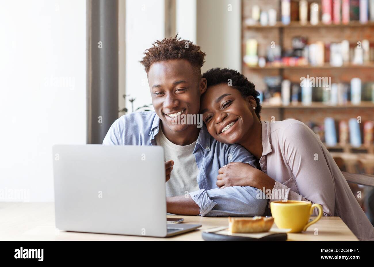 Schwarzes Paar in der Liebe, das Unterhaltung Video zusammen im Stadtcafe ansieht Stockfoto