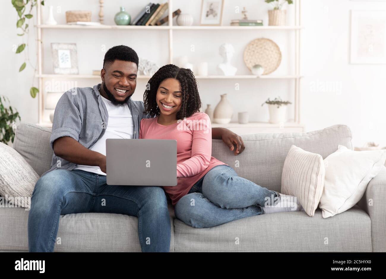 Wochenend-Freizeit. Verheiratet Afro-Paar Mit Laptop Zu Hause Zusammen, Filme Ansehen Stockfoto