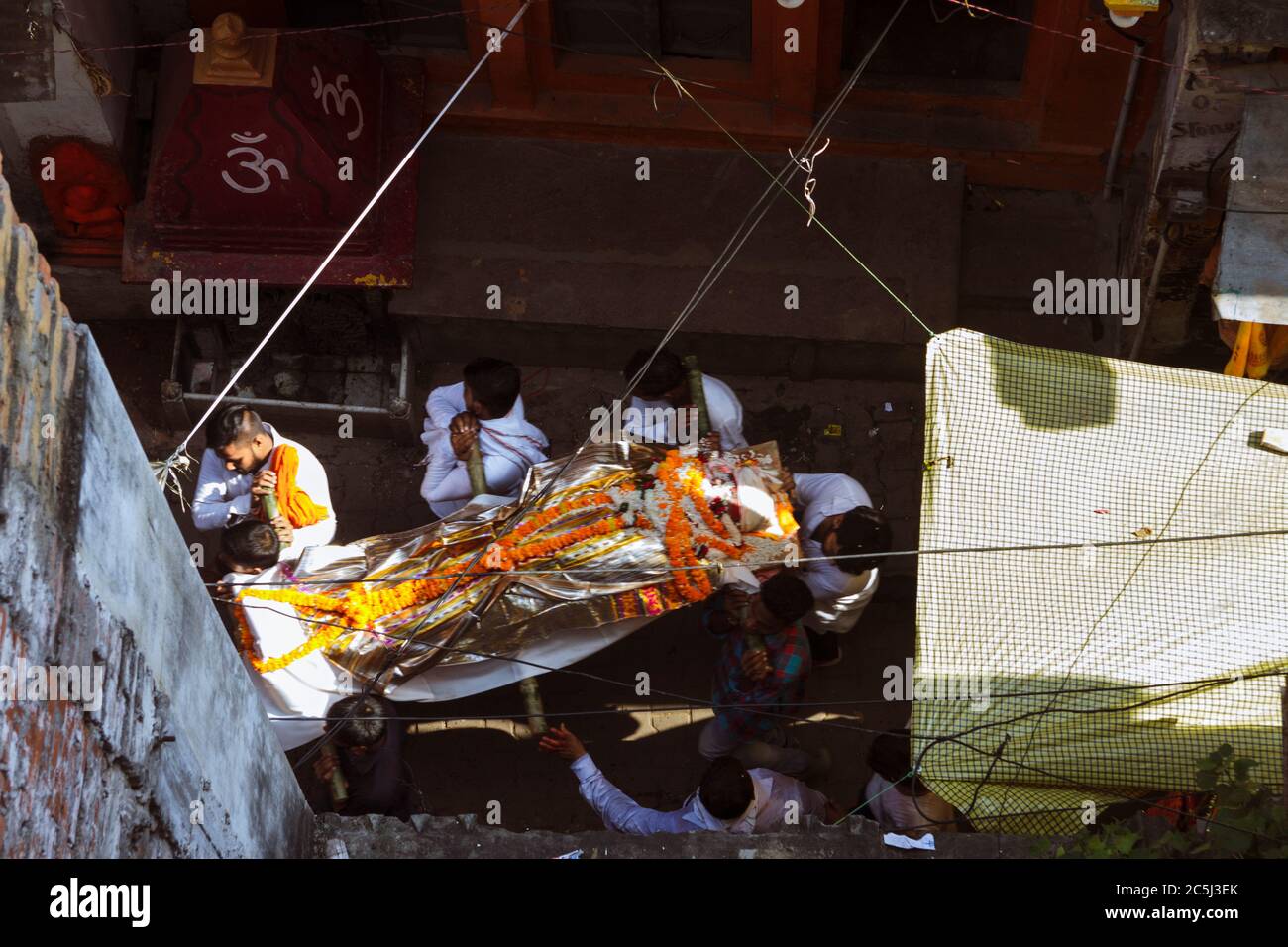 Varanasi, Uttar Pradesh, Indien: EINE Gruppe Trauergänger tragen einen ummantelten Körper über die engen Gassen der Altstadt für seine Einäscherung bei Manikarnika g Stockfoto