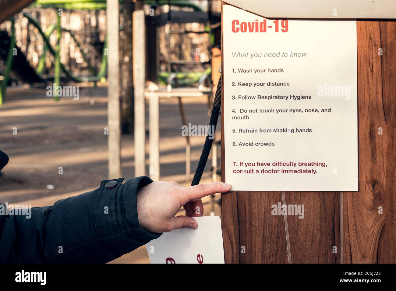 Notieren Sie covid-19, was Sie wissen müssen. Auf einem leeren Spielplatz in einem Park hängen. Selbstisolierung und Quarantäne bei einer Pandemie. Stockfoto