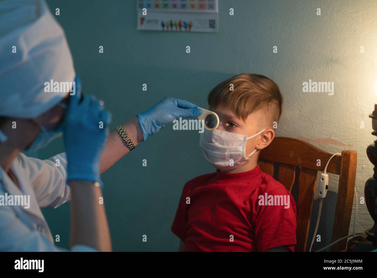 Kind bei Termin mit einem Optiker. Die Ärztin überprüft das Augenlicht des Jungen. Stadtkrankenhaus. Mai 2020, Brovary, Ukraine Stockfoto