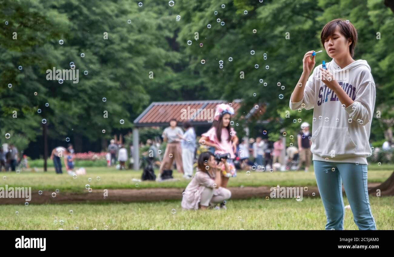 Jugendliche spielen mit Blasen im Yoyogi Park, Tokyo, Japan Stockfoto