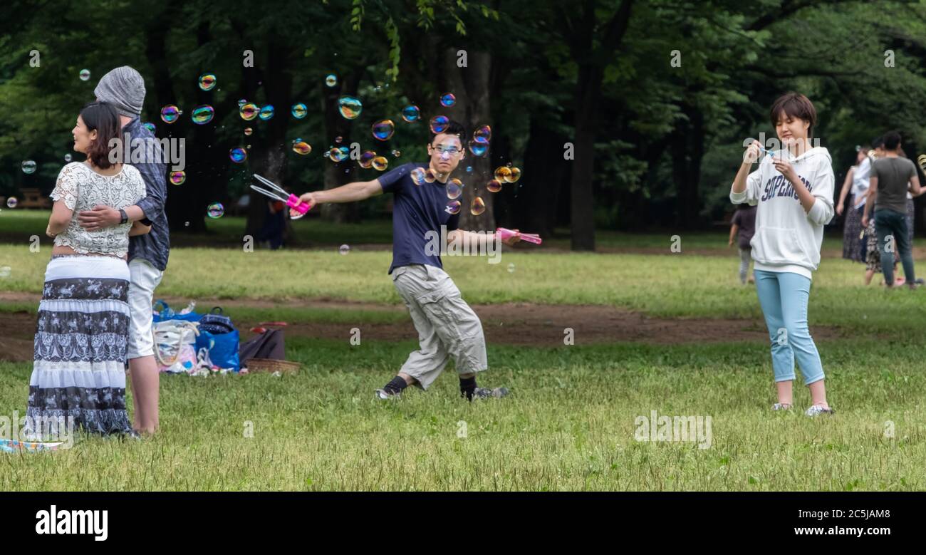 Jugendliche spielen mit Blasen im Yoyogi Park, Tokyo, Japan Stockfoto