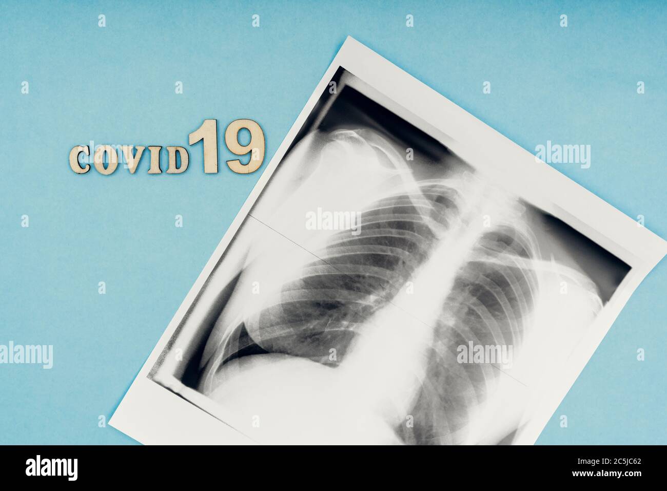 Coronavirus, covid-19. Die Inschrift covid-19 und Röntgenaufnahme der Lunge auf blauem Hintergrund. Selbstisolation und Quarantäne, Lungenentzündung Stockfoto