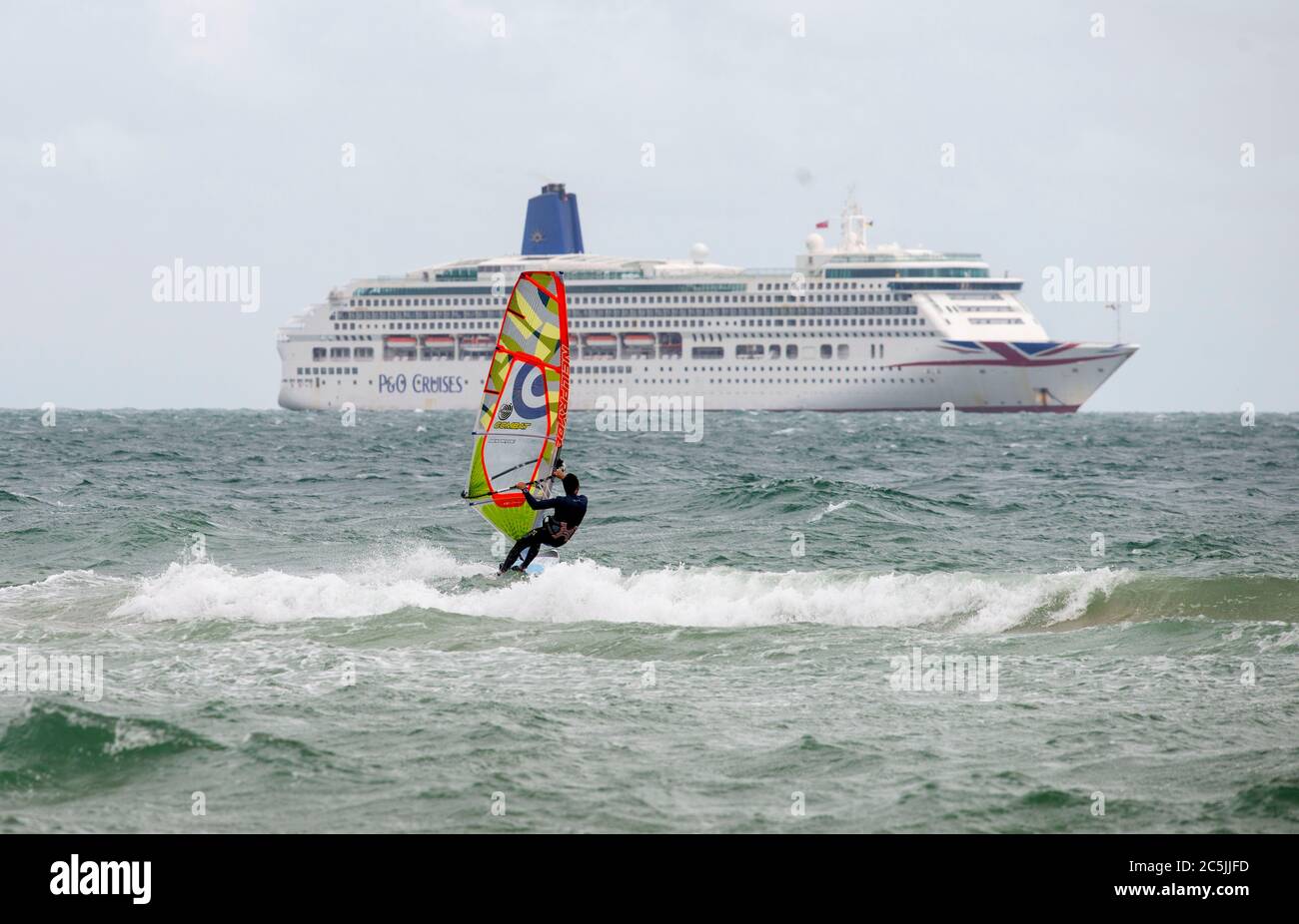Bournemouth, Dorset, Großbritannien, 3. Juli 2020. Ein einsamer Windsurfer passiert ein Kreuzfahrtschiff am Bournemouth Beach, da die COVID-19-Sperrregeln in Großbritannien gelockert sind. Credit John Beasley/Alamy Live News Stockfoto