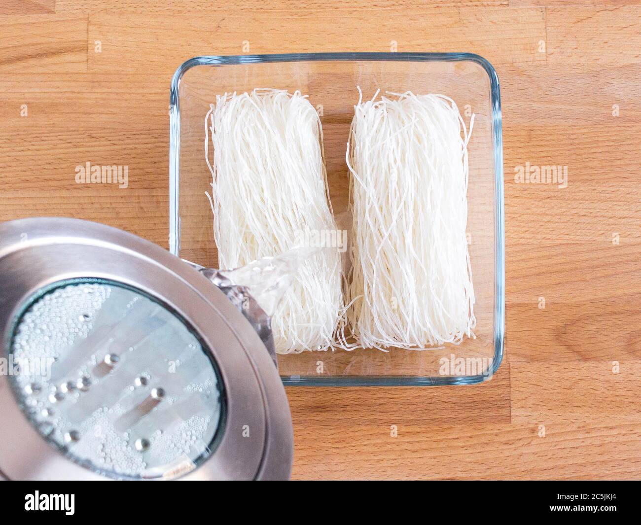 Kochen fjunchoza. Die Vermicelli mit heißem Wasser gießen. Stockfoto