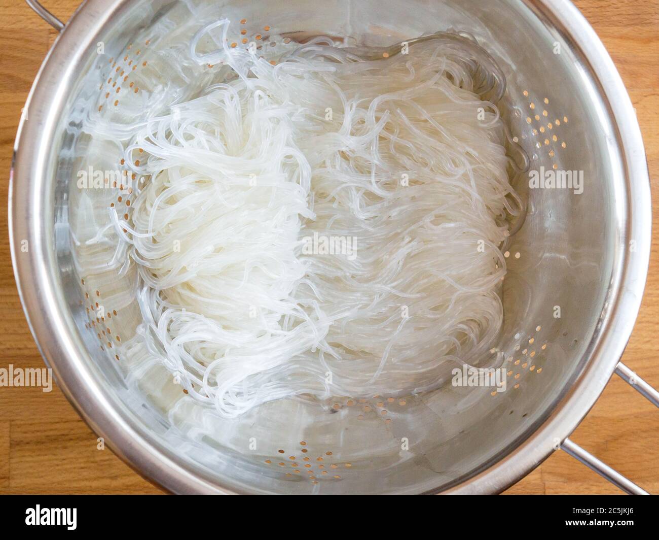 Das Wasser aus der Fjunchoza ablassen. Kochen klare Nudeln. Vermicelli in einem Sieb. Stockfoto