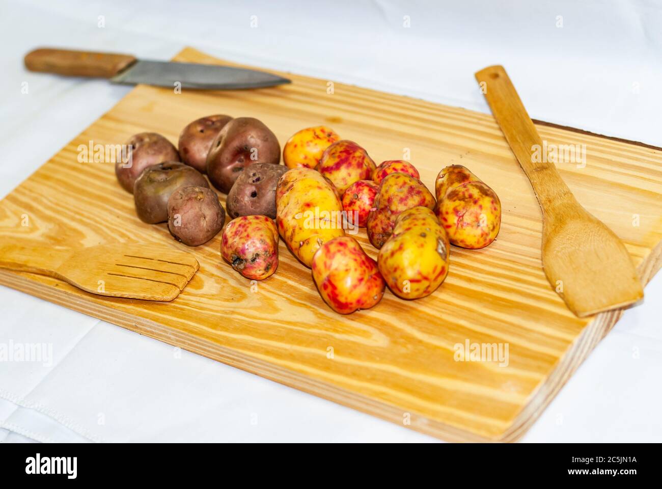 Regionale Kartoffeln aus den Anden auf einem Markt in Peru, Bolivien, Argentinien, Südamerika auf einem Holztisch. Selektiver Fokus Stockfoto