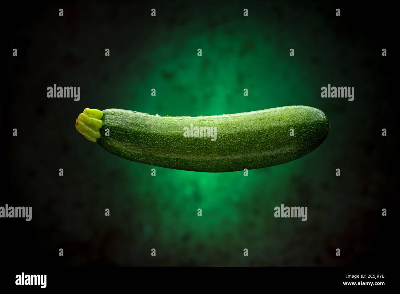 Nass Zucchini schwimmend mit grünem Hintergrund Stockfoto