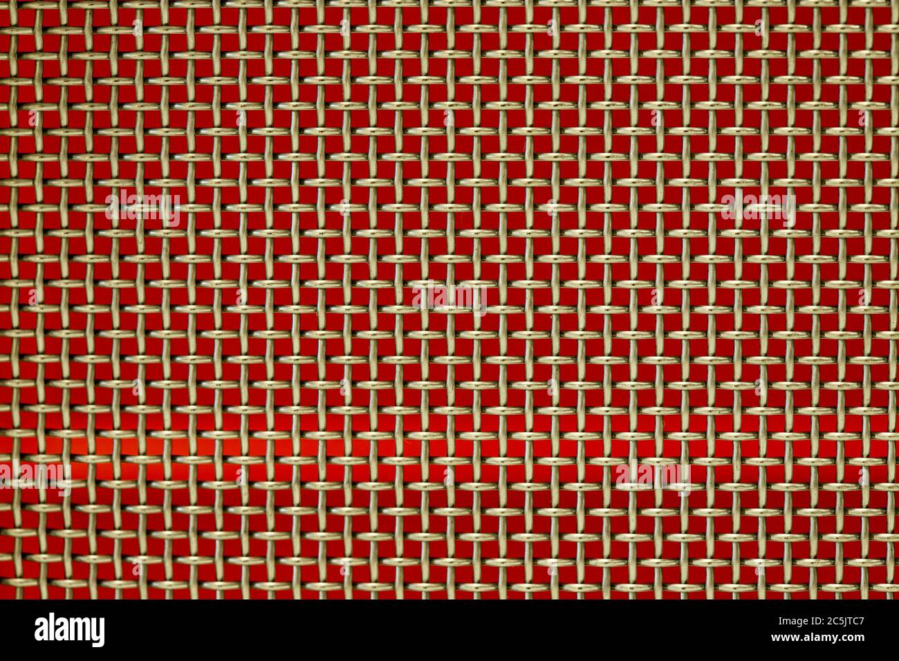 Gewebtes Drahtgeflecht mit rotem Hintergrund. Computer-Desktop. Stockfoto