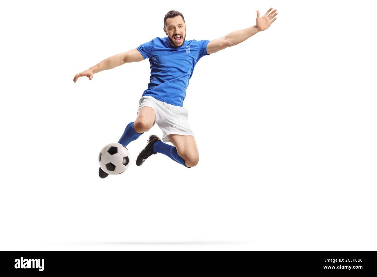 Fußballspieler springen und treten einen Ball isoliert auf weißem Hintergrund Stockfoto