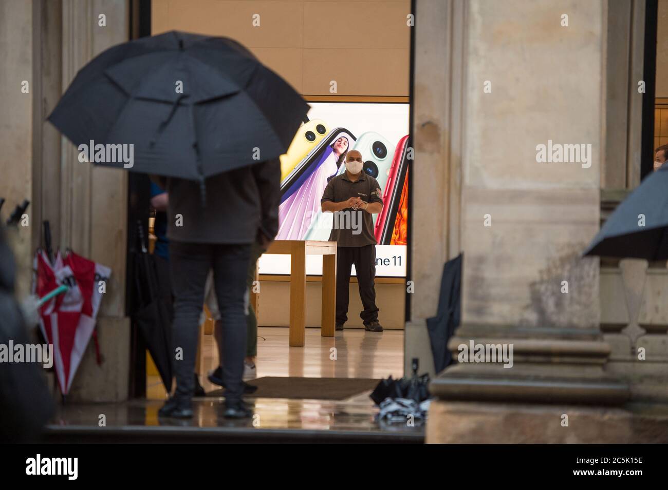 Glasgow, Schottland, Großbritannien. Juli 2020. Im Bild: Buchanan Street Shopping-Bereich mit Käufern trotzen dem strömenden Regen mit Regenschirmen und Gesichtsbezügen, die am 10. Juli nächste Woche obligatorisch werden. Quelle: Colin Fisher/Alamy Live News Stockfoto